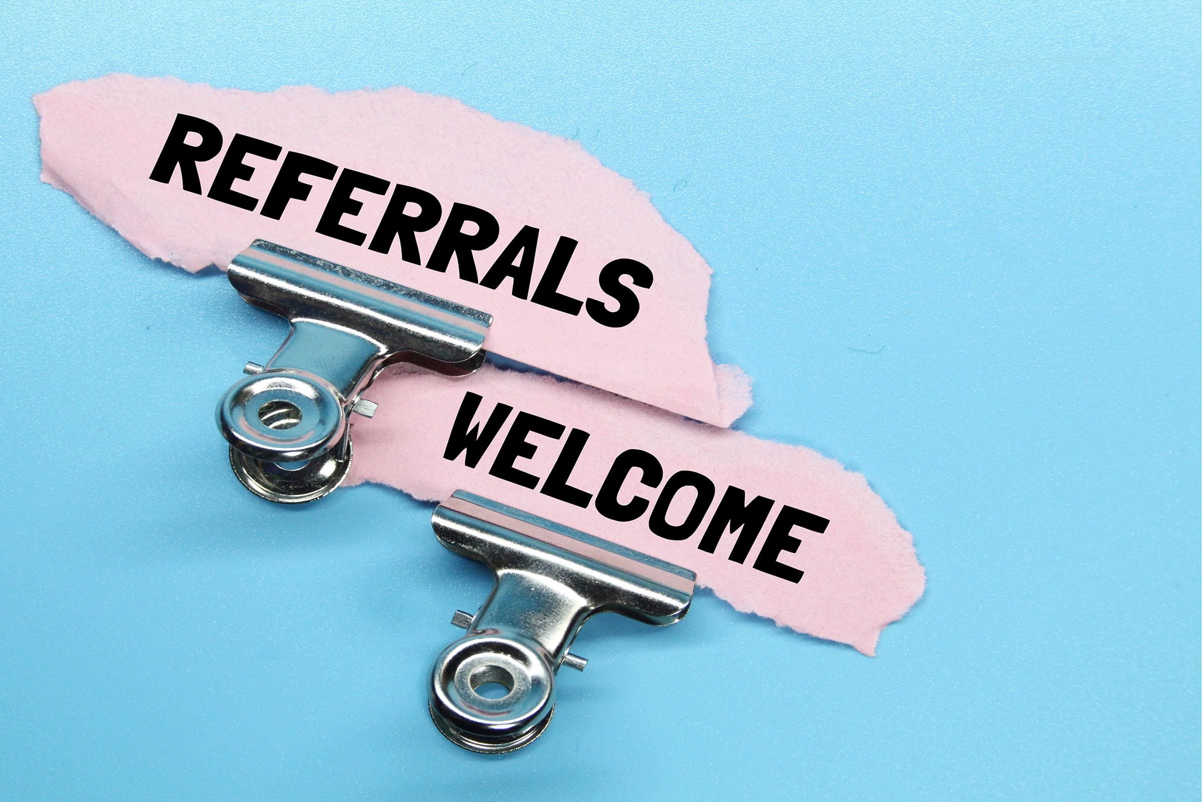 Clipboards with 'Referrals Welcome' sign